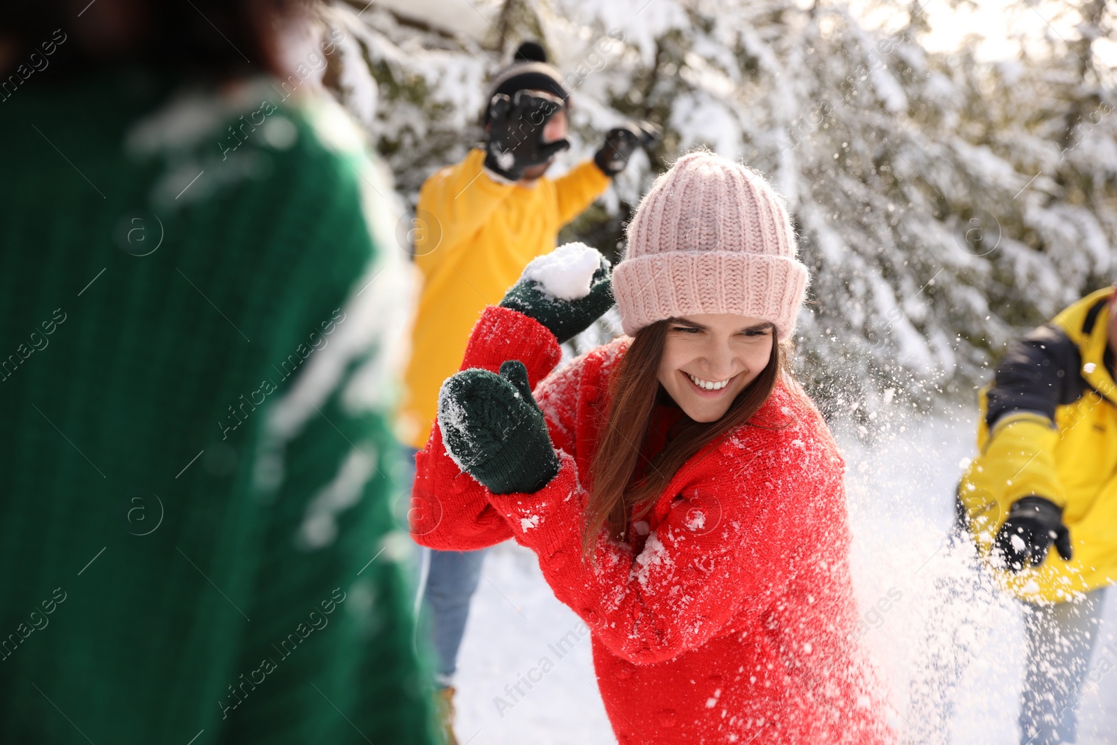 Photo of Happy friends playing snowballs outdoors. Winter vacation