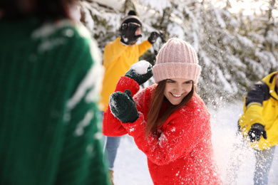 Photo of Happy friends playing snowballs outdoors. Winter vacation