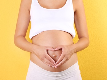 Photo of Pregnant woman posing on color background, closeup