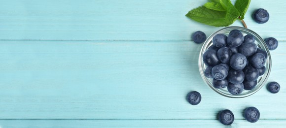 Image of Tasty fresh blueberries on turquoise wooden table, flat lay with space for text. Banner design