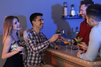 Young man taking martini cocktail from barman at party