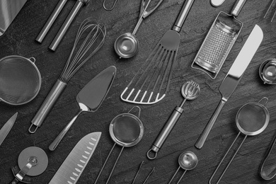 Photo of Cooking utensils on black table, flat lay