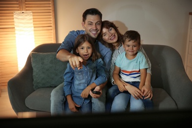 Photo of Family watching TV in room at evening time