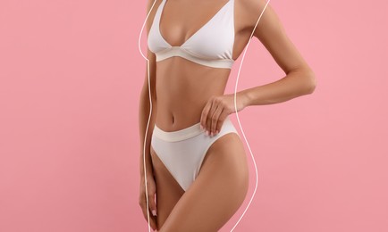 Image of Woman showing her beautiful figure on pink background, closeup. Her body outline before cosmetic treatment