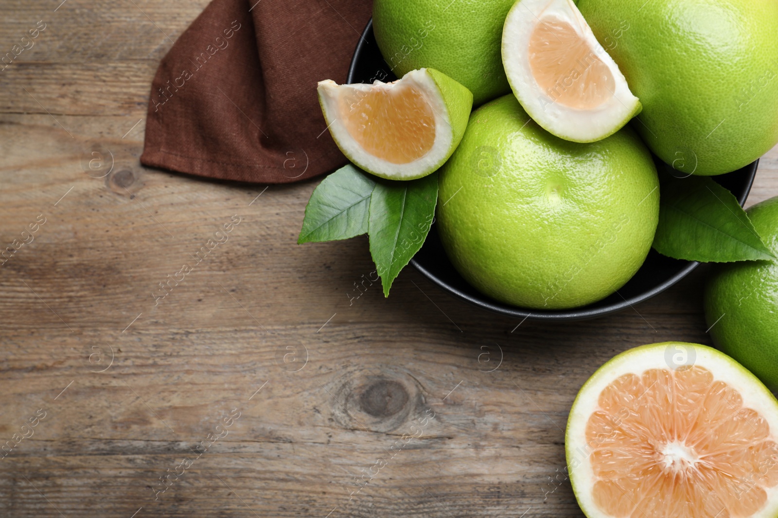 Photo of Fresh ripe sweetie fruits on wooden table, flat lay. Space for text