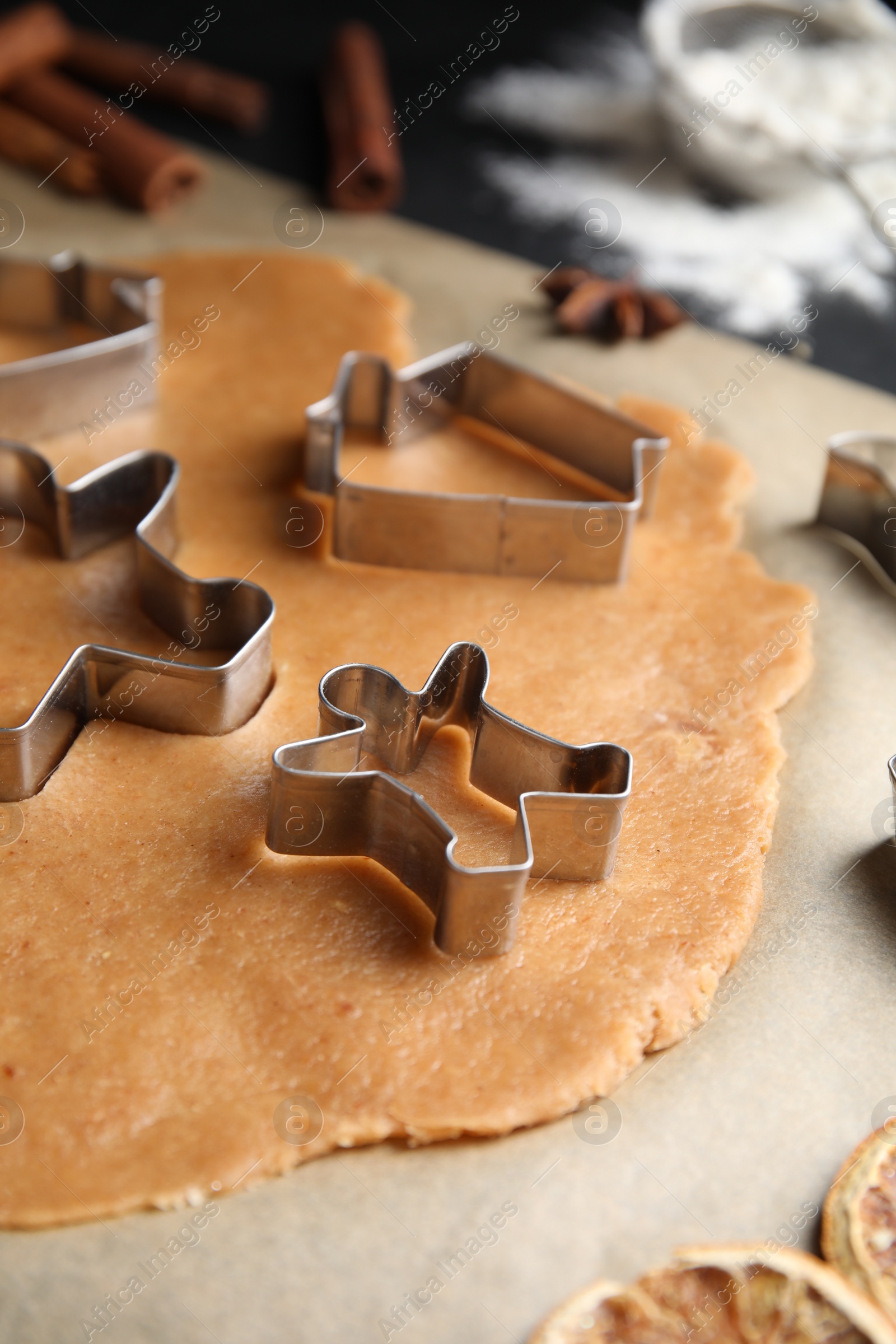 Photo of Making homemade Christmas cookies. Dough and cutters on table, closeup