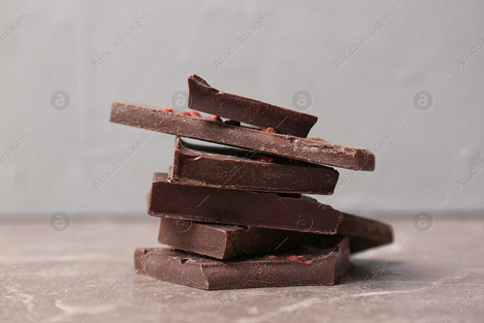 Photo of Pieces of delicious dark chocolate on table