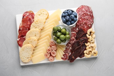 Photo of Tasty parmesan cheese and other different appetizers on white table, top view