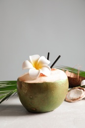 Fresh green coconut on table against gray background