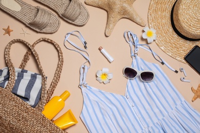 Beach accessories on beige background, flat lay