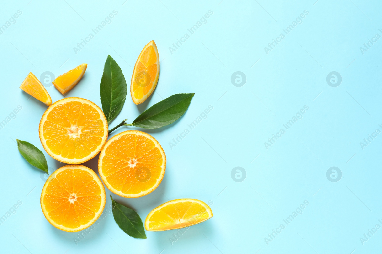 Photo of Fresh oranges and leaves on color background, flat lay with space for text. Citrus fruits