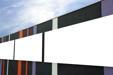 Photo of Blank advertising boards on city building. Mockup for design