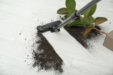 Photo of Removing soil from wooden floor with vacuum cleaner at home