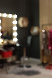 Blurred view of makeup room with stylish mirror near dressing table and chair