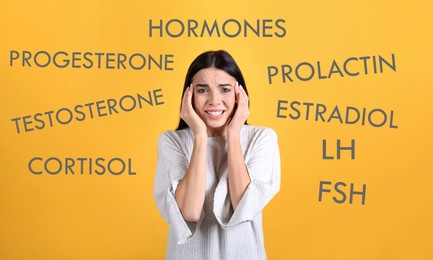 Hormones imbalance. Stressed young woman and different words on yellow background