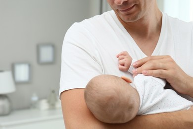 Photo of Happy father holding his cute baby at home, space for text