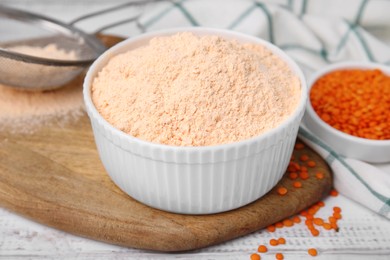 Bowl of lentil flour and seeds on white wooden table, closeup