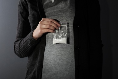 Female dealer holding drugs in plastic bag, closeup