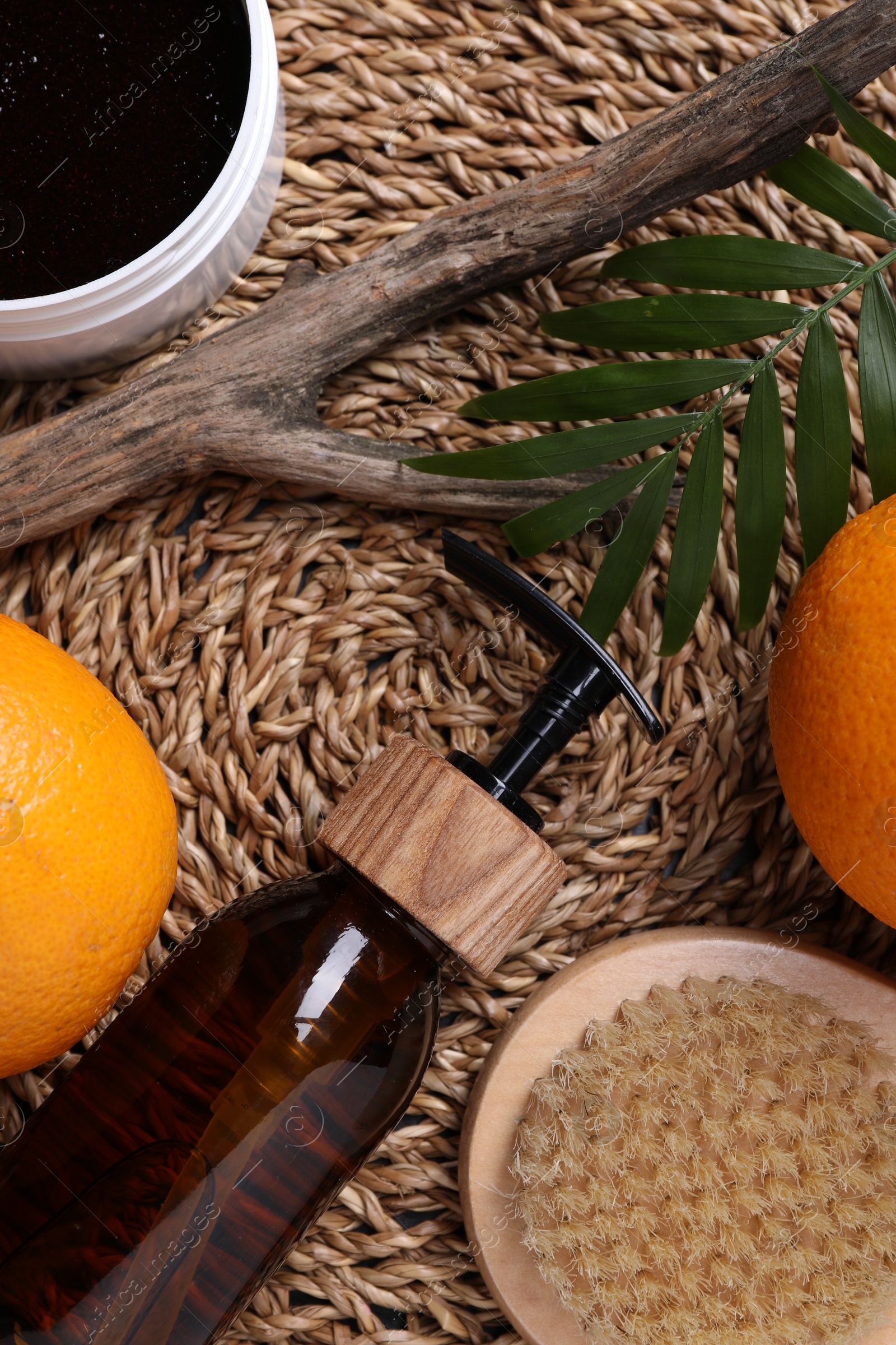 Photo of Flat lay composition with bottle of cosmetic product and oranges on wicker surface. Cellulite treatment