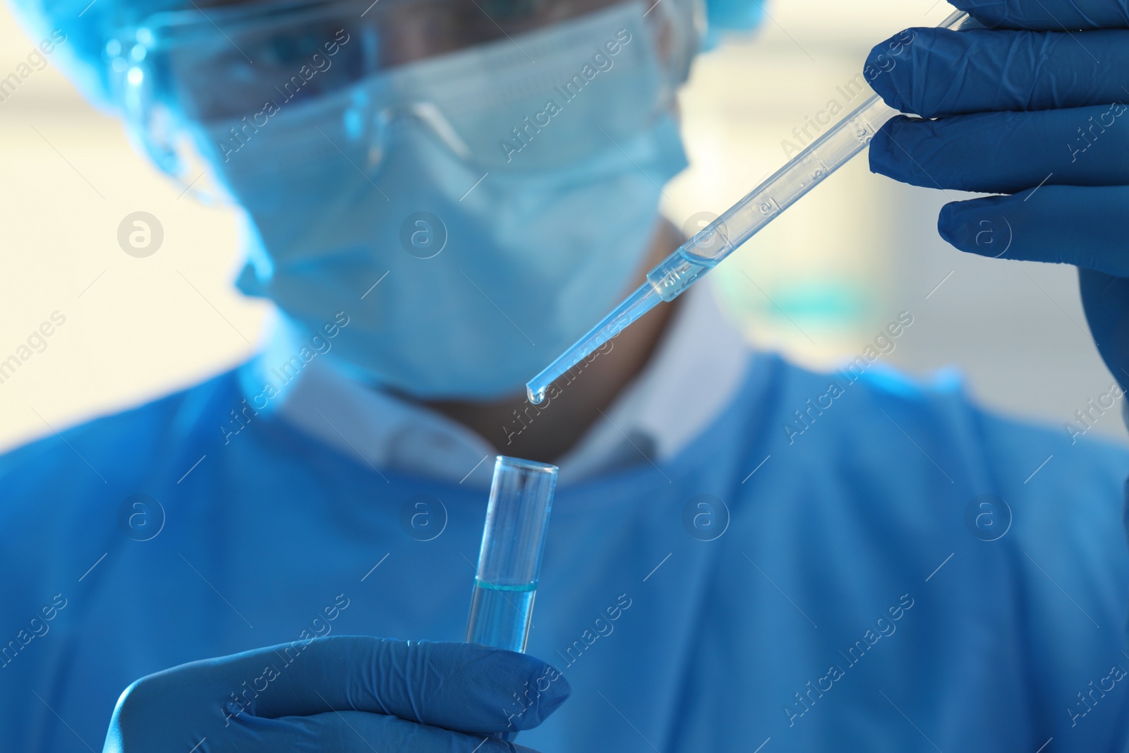 Photo of Scientist dripping sample into test tube in laboratory, closeup. Medical research