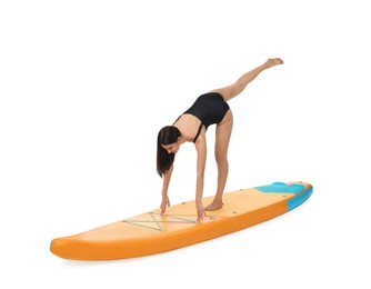 Woman practicing yoga on orange SUP board against white background
