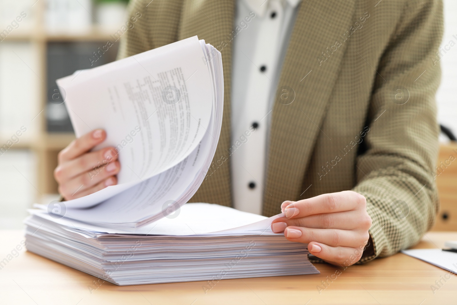 Photo of Woman working with documents at table in office, closeup