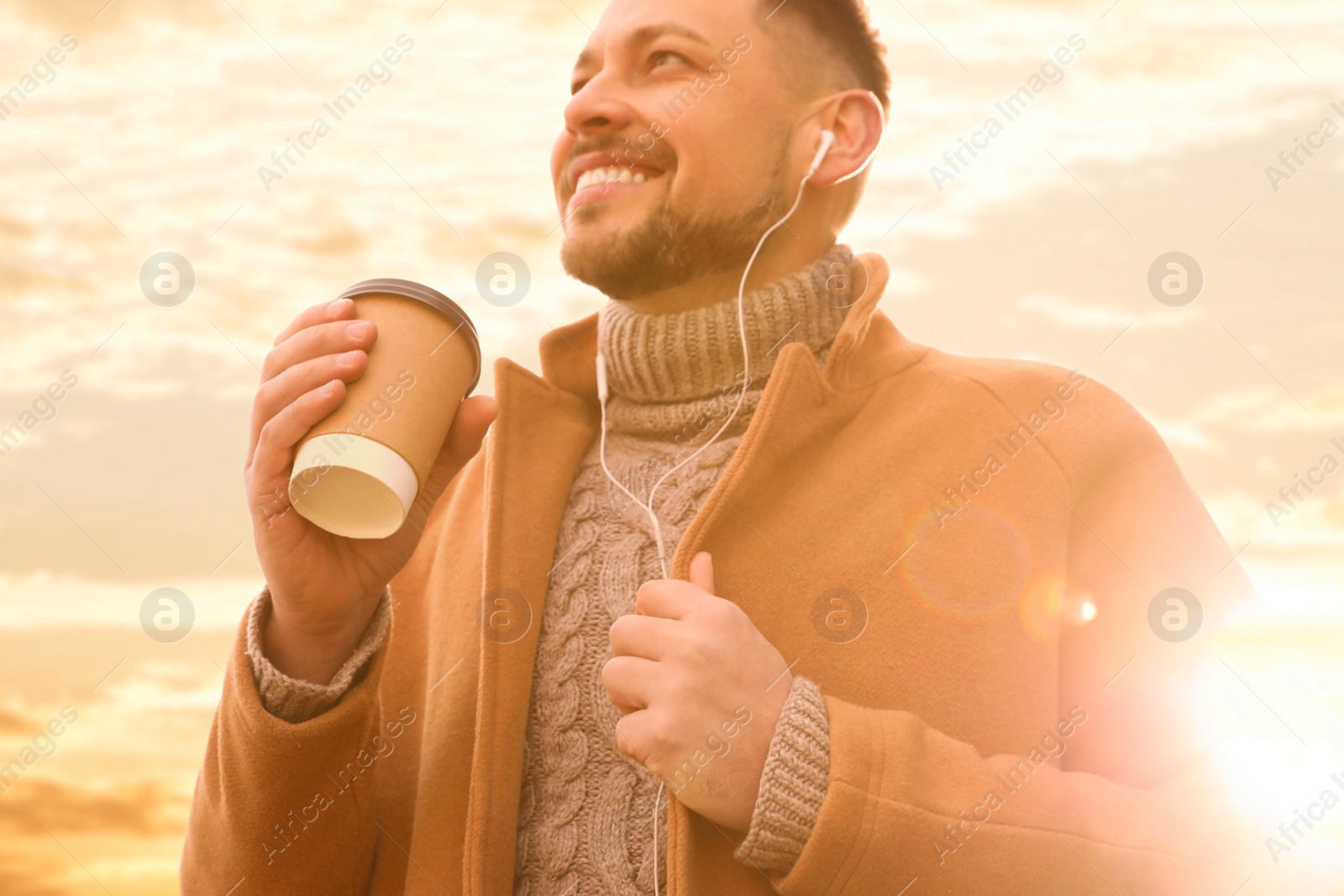 Photo of Man with cup of coffee on city street in morning