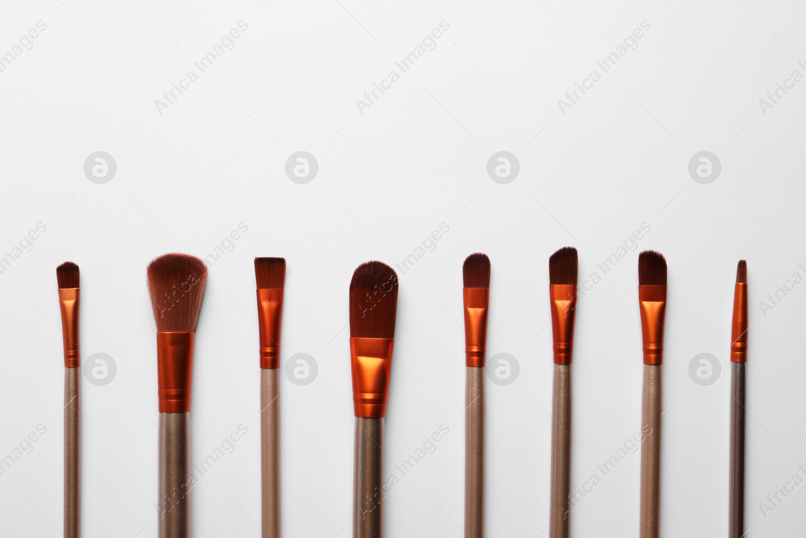 Photo of Different makeup brushes on white background, flat lay