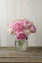Photo of Beautiful peonies in vase on wooden table