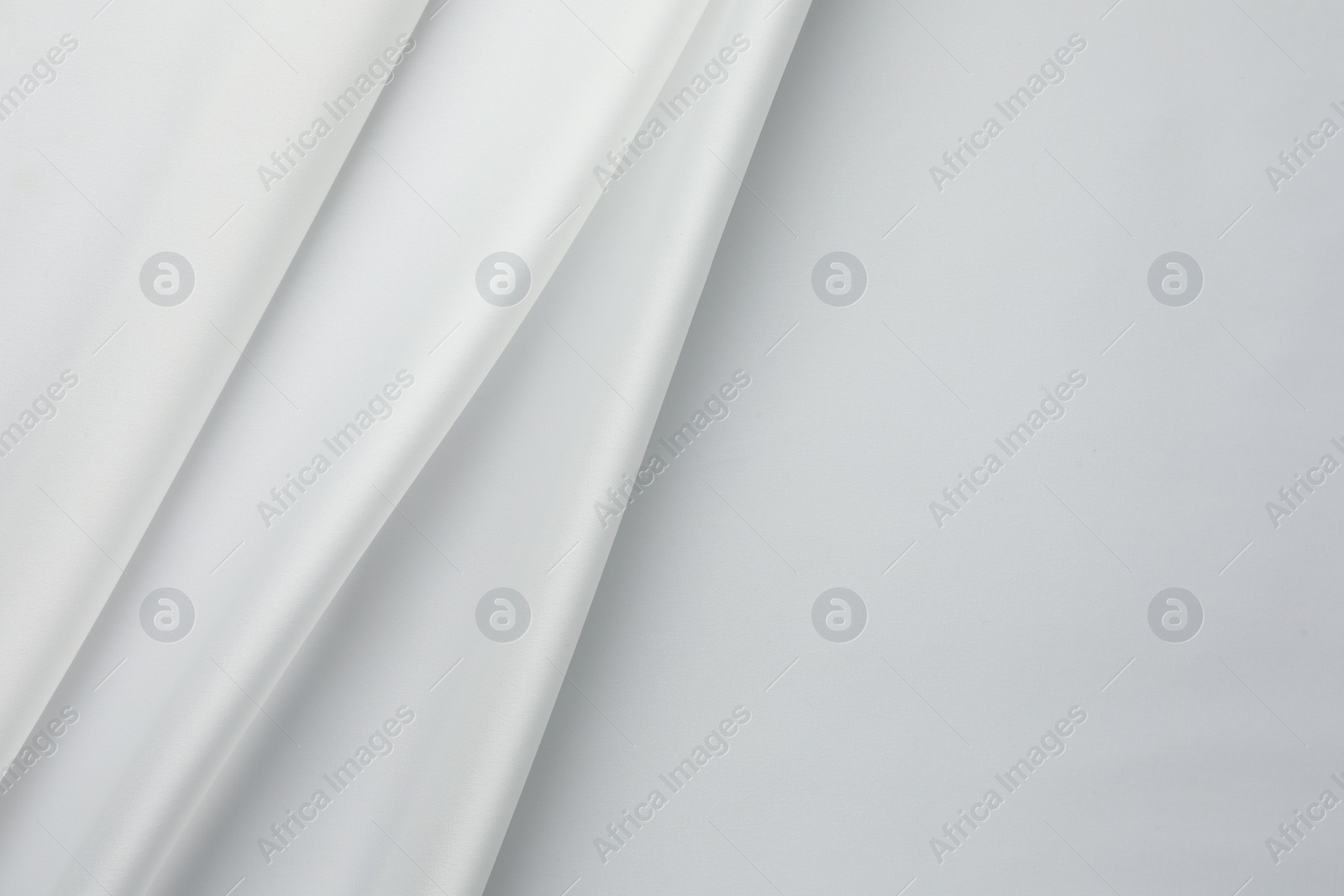 Photo of Texture of crumpled white silk fabric as background, top view. Space for text