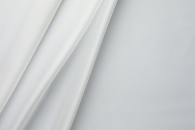 Photo of Texture of crumpled white silk fabric as background, top view. Space for text