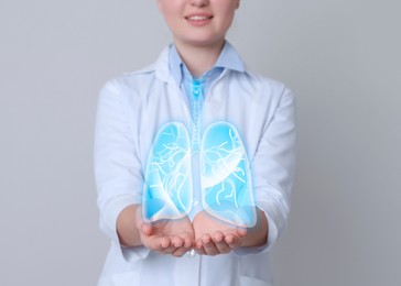 Image of Doctor demonstrating digital image of human lungs on light grey background, closeup