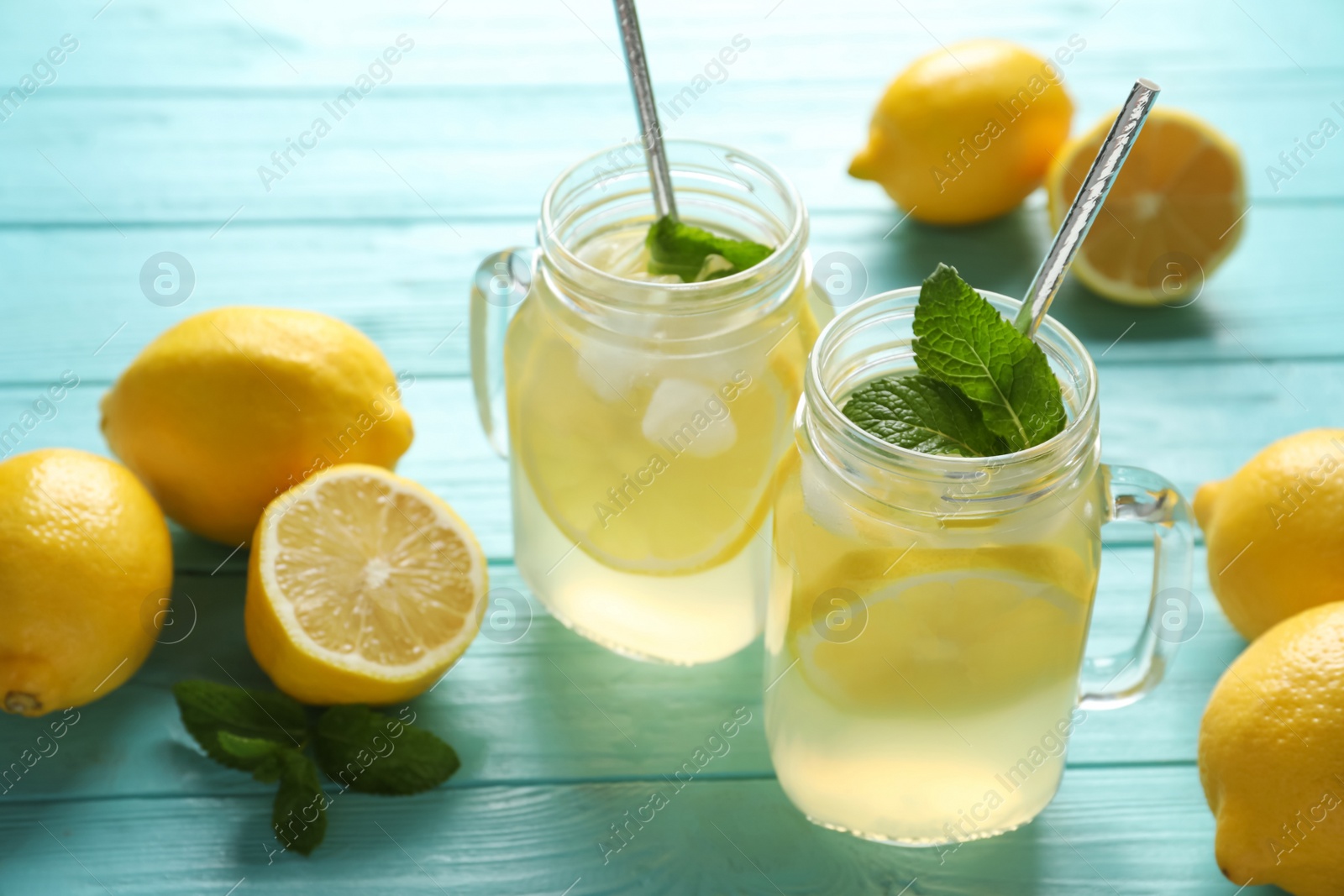 Photo of Natural lemonade with mint on light blue wooden table. Summer refreshing drink