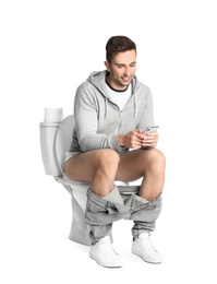 Photo of Man with smartphone sitting on toilet bowl, white background