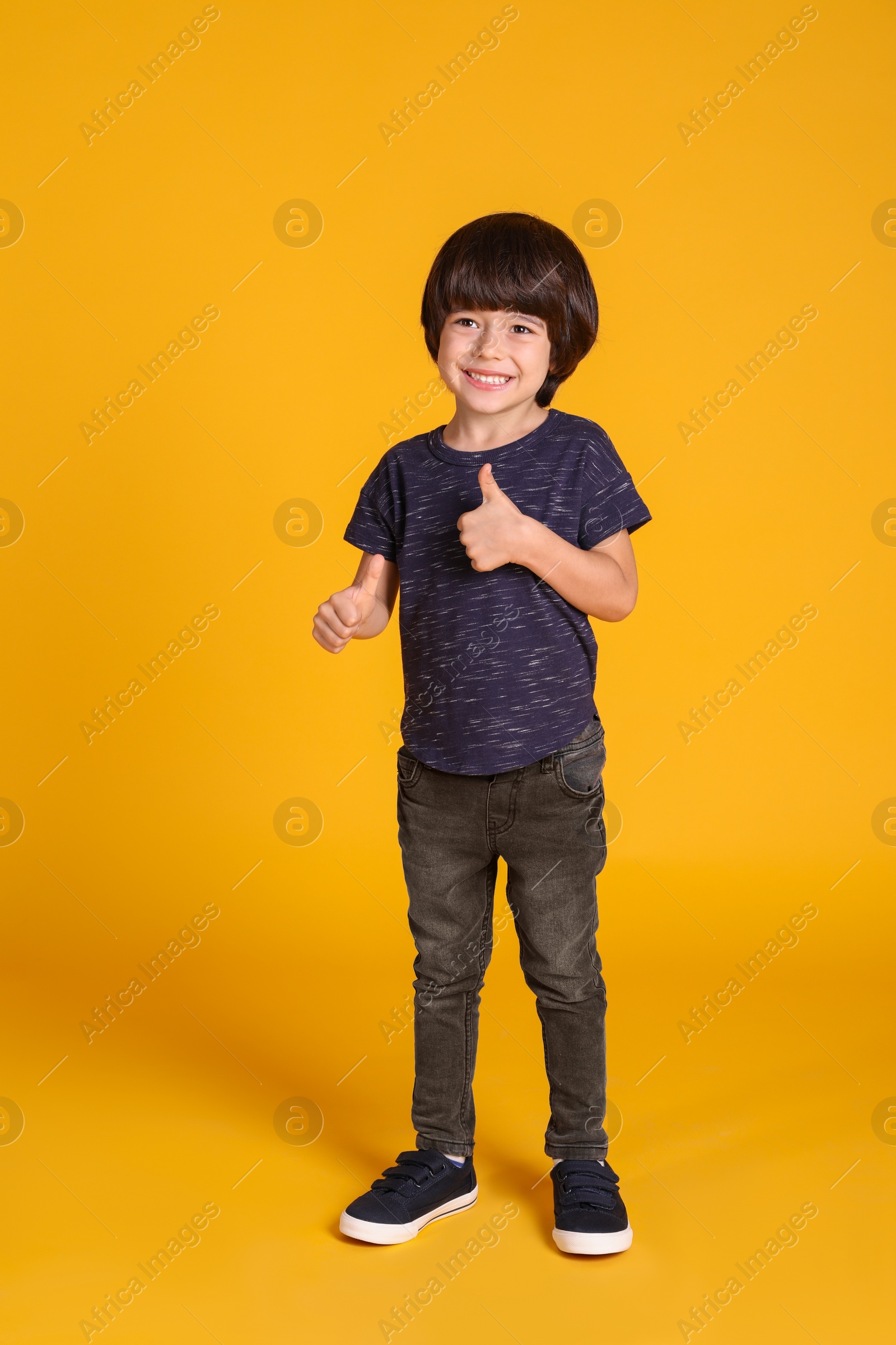 Photo of Full length portrait of cute little boy on yellow background