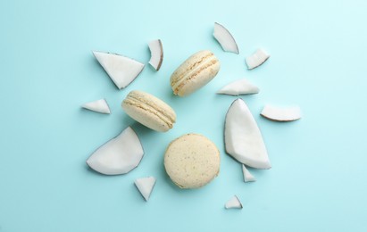 Photo of Flat lay composition with macarons and pieces of coconut on light blue background