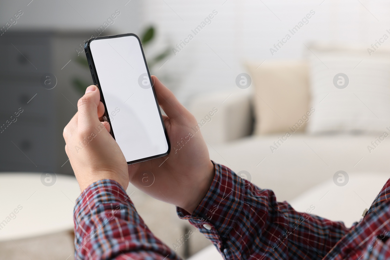 Photo of Man using mobile phone indoors, closeup view