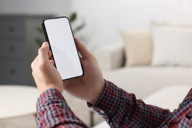 Man using mobile phone indoors, closeup view