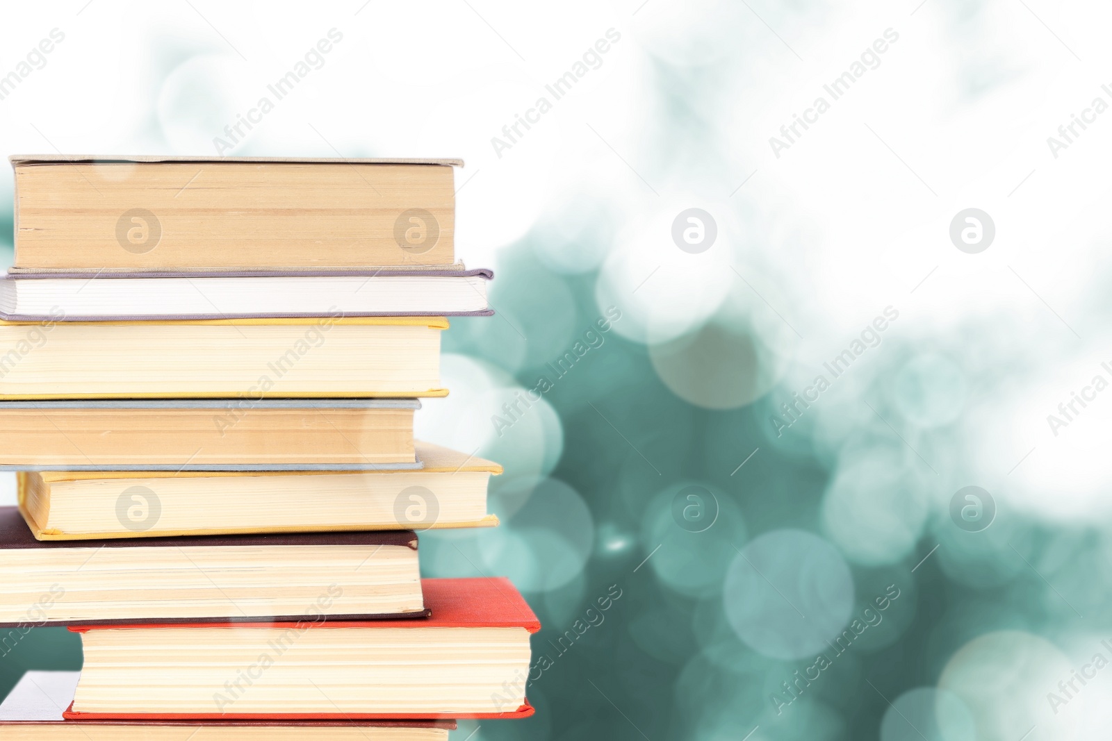 Image of Stack of books on blurred background, space for text. Bokeh effect 