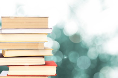 Image of Stack of books on blurred background, space for text. Bokeh effect 