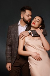 Handsome bearded man with sexy lady on grey background