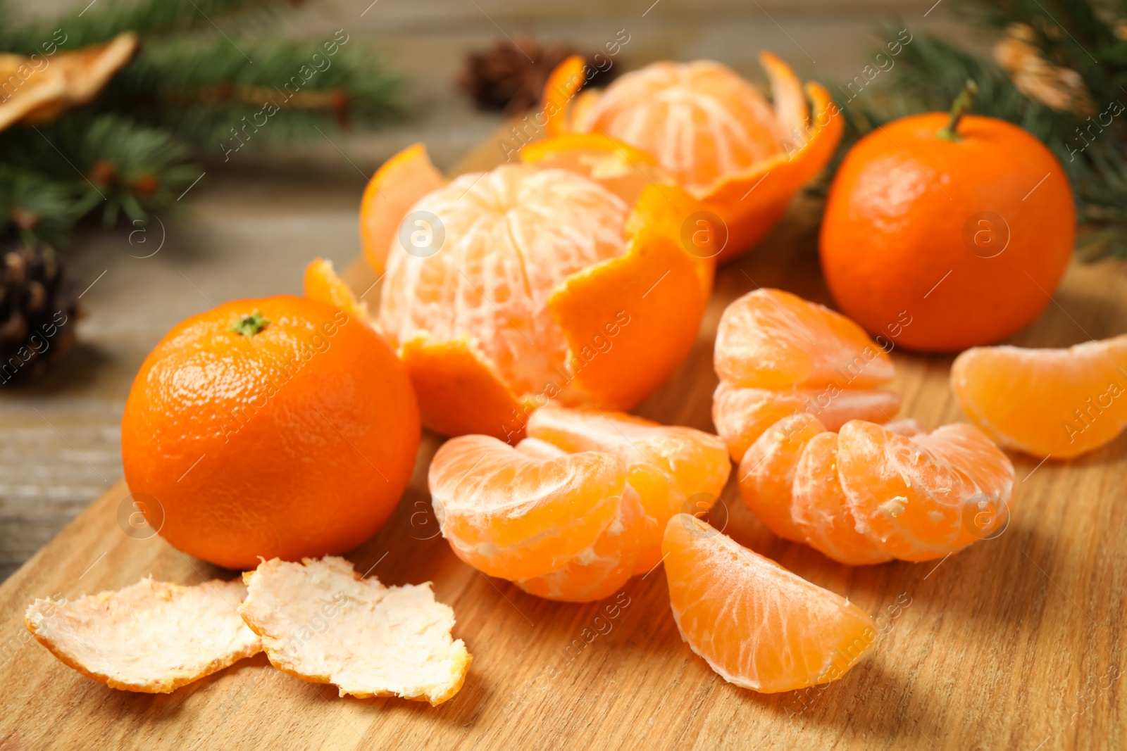 Photo of Fresh tangerines on wooden board, closeup. Christmas atmosphere