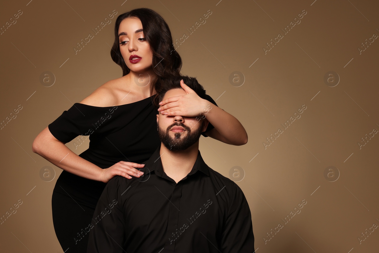 Photo of Bearded man with sexy lady on light brown background. Space for text