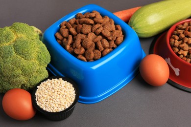 Dry pet food and products on black background, closeup