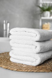 Stacked bath towels on light table in bathroom