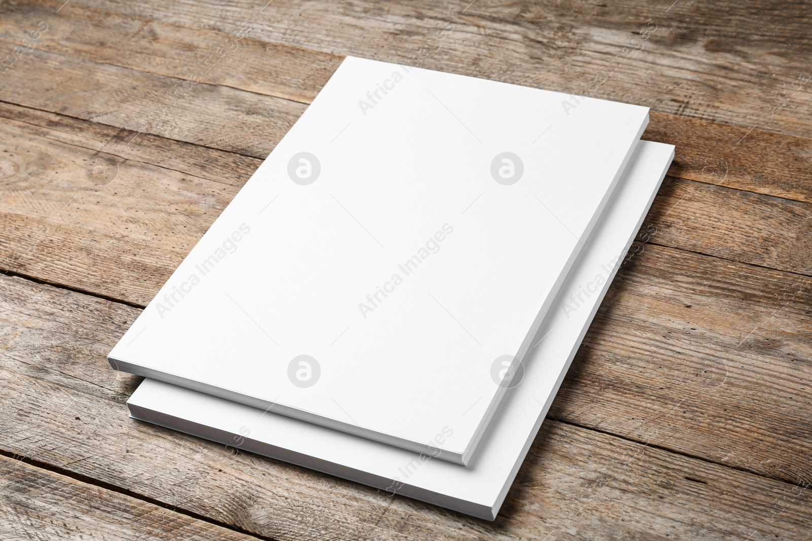 Photo of Stack of blank paper sheets for brochure on wooden background. Mock up