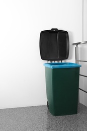 Photo of Trash bin on stair landing indoors. Waste recycling