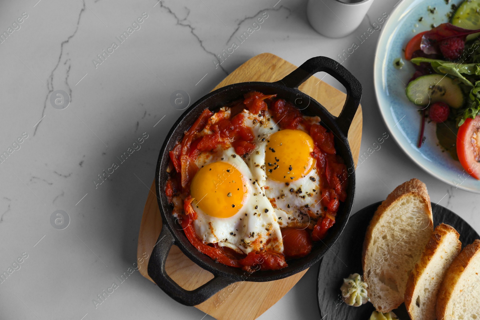 Photo of Tasty Shakshouka served on white marble table, flat lay. Space for text