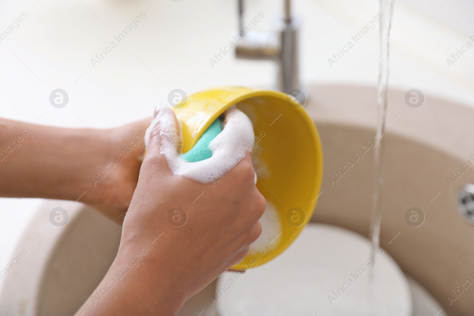 Photo of Woman washing dirty dishes in kitchen sink, closeup. Cleaning chores