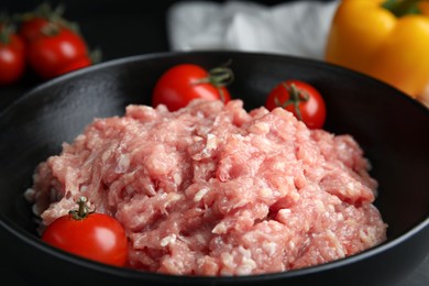 Raw chicken minced meat with tomatoes in bowl, closeup